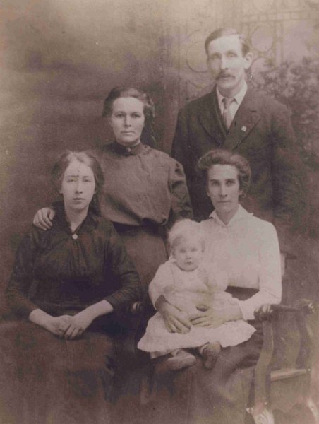 7-Butler_Lethbridge.jpg - Standing in the back are Elizabeth Butler (nee Lethbridge) #136 and husband Hezekiah Butler #134. Sitting in front (L-to-R) unknown person, the baby is Mary Prudence Butler #182, daughter of Elizabeth and Hezekiah and holding Mary is Hanna Clover Lethbridge #7, sister of Elizabeth.  Source: Wayne Butler, email to WJG, 2001.08.07.